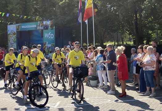 Deelnemers in geel shirt bij start