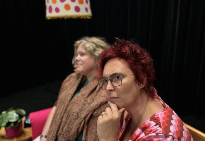 Een vrouw die bedenkelijk kijkt, een andere vrouw kijkt weg