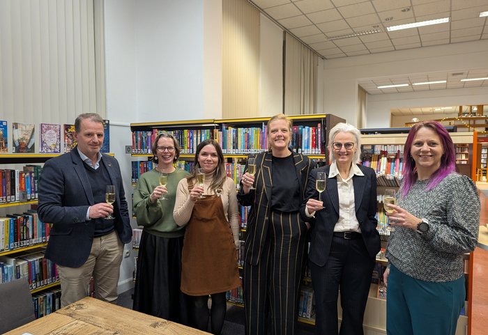 Mensen heffen een glas op de ondertekening